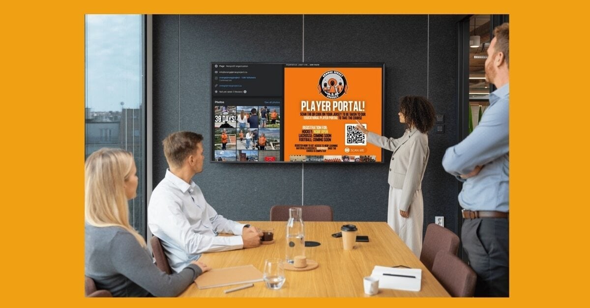 Orange Jersey Project Facebook post about their educational player portal with open registration for eLearning courses for young athletes which PathWise Solutions created is on screen in the boardroom where an imaginary marketing team is discussing a marketing strategy